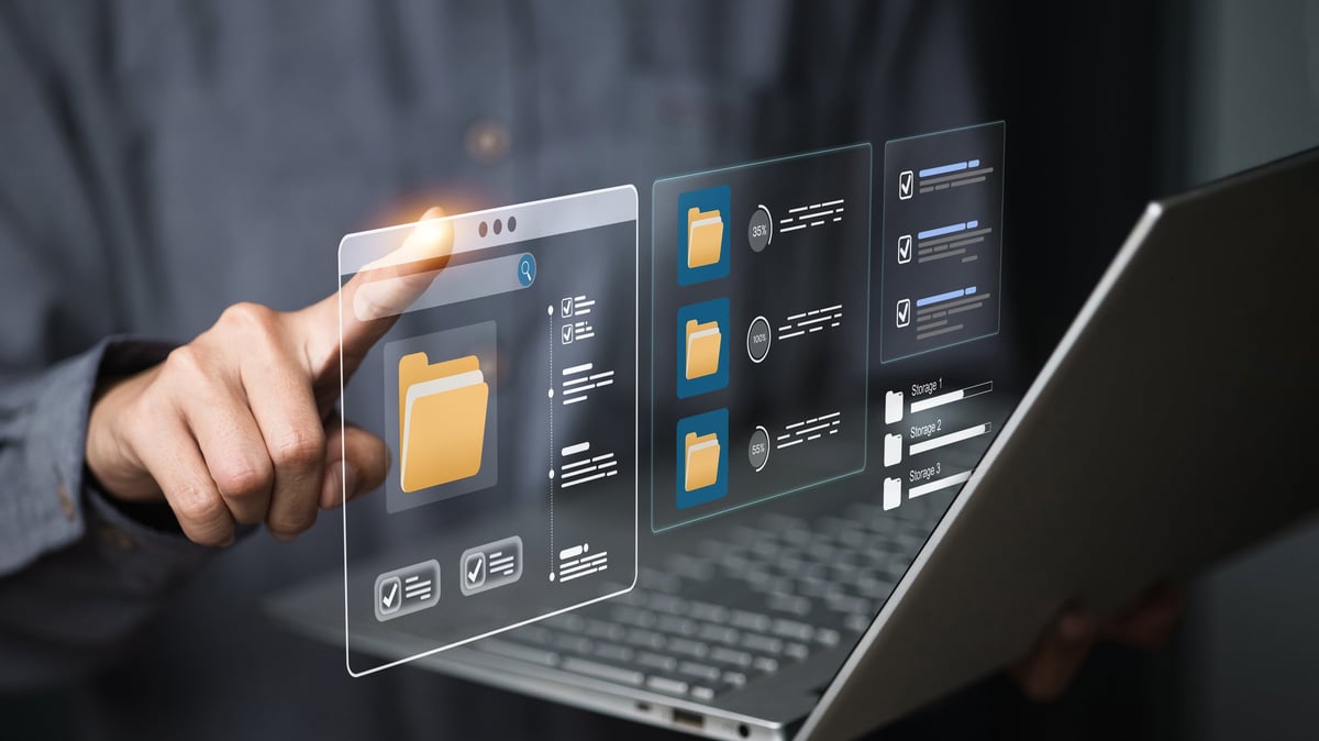 Person uses a laptop and touches floating file-manager panels showing folders, progress bars and checklists. Concept of cloud storage, document workflow, backup and secure data organization for business.